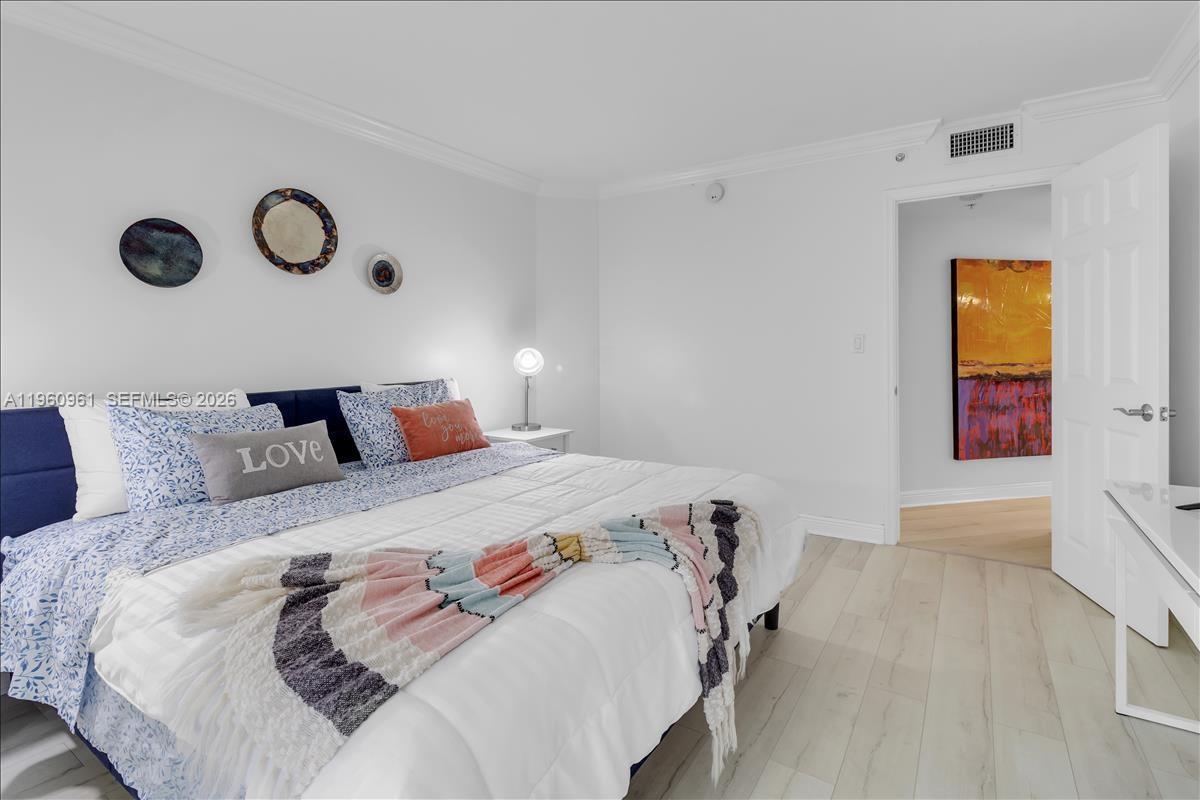 A bedroom features a king bed with patterned bedding, a throw blanket, and wall art — 3000 N Ocean Dr # 3B, Singer Island FL 33404, SINGER ISLAND, FL