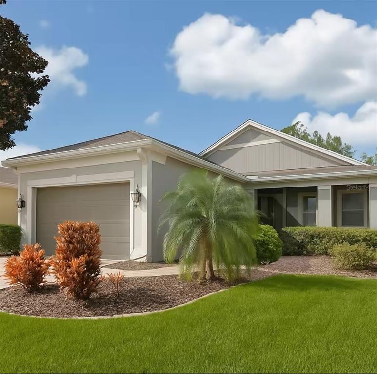 A single-story house with a gray exterior, a two-car garage, and a front palm tree — 119 CRESCENT MOON DRIVE, GROVELAND, FL