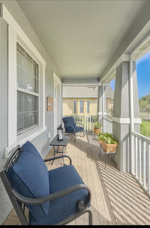 A covered front porch features gray walls, a brick floor, and two blue patio chairs — 119 CRESCENT MOON DRIVE, GROVELAND, FL