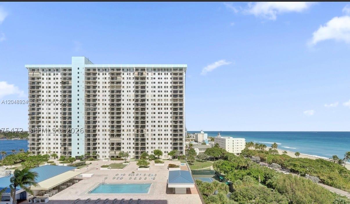 An exterior view of a high-rise apartment building featuring a swimming pool and oceanfront grounds — 1201 S Ocean Dr # 410S, Hollywood FL 33019, HOLLYWOOD, FL