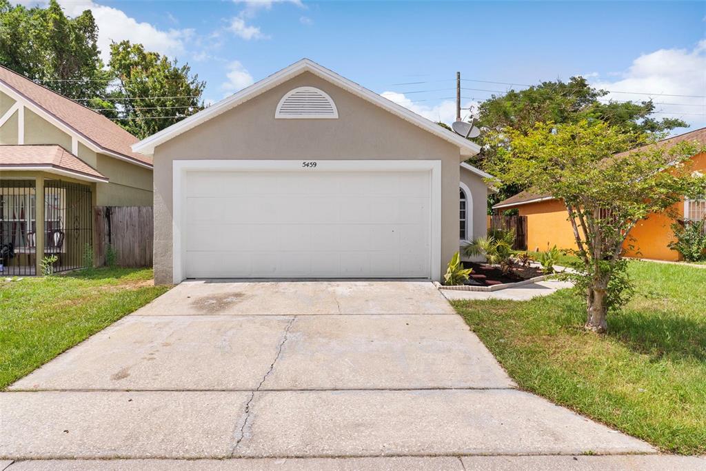 A detached garage with a white door and a concrete driveway in a residential yard — 5459 SEEDLING LANE, ORLANDO, FL