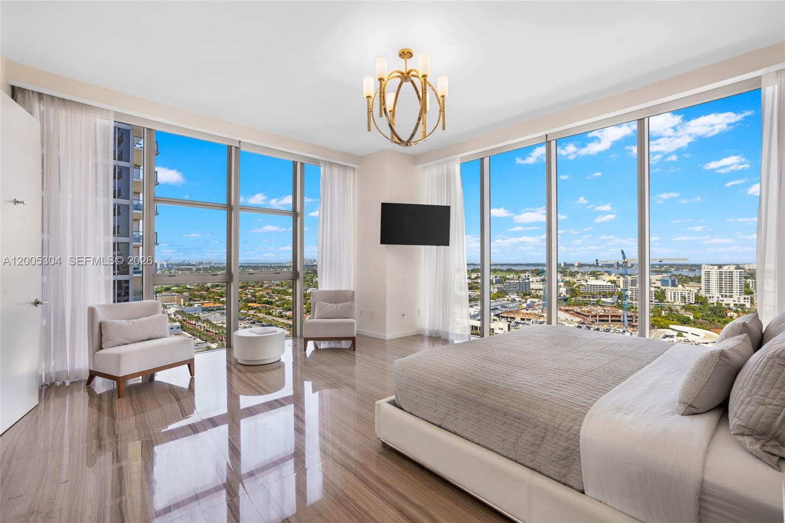 A modern bedroom features floor-to-ceiling windows, a large bed, and polished wood-look flooring — 9705 Collins Ave # 1805N, Bal Harbour FL 33154, BAL HARBOUR, FL