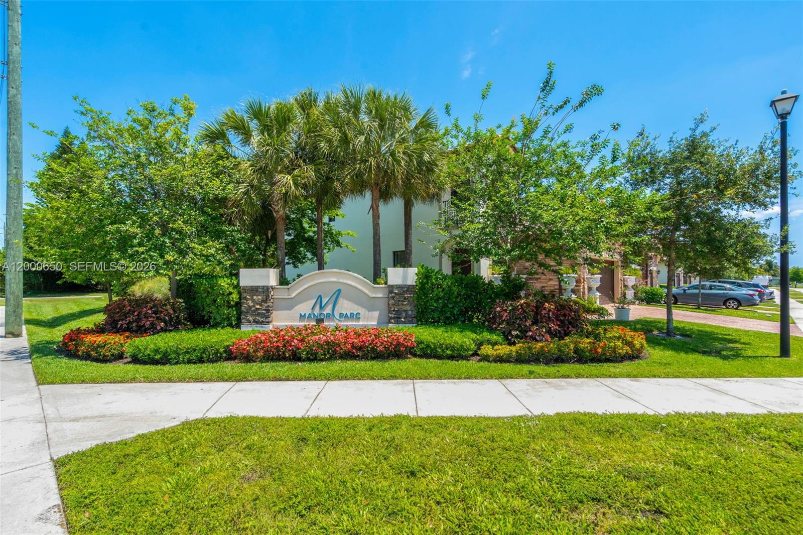 A stone monument sign for Manor Parc stands in front of trees and a sidewalk — 5113 NW 52nd St, Tamarac FL 33319, TAMARAC, FL