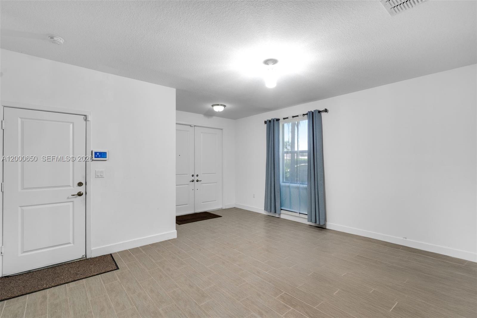 An interior view shows a room with light-colored tile flooring, white walls, and two white doors — 5113 NW 52nd St, Tamarac FL 33319, TAMARAC, FL
