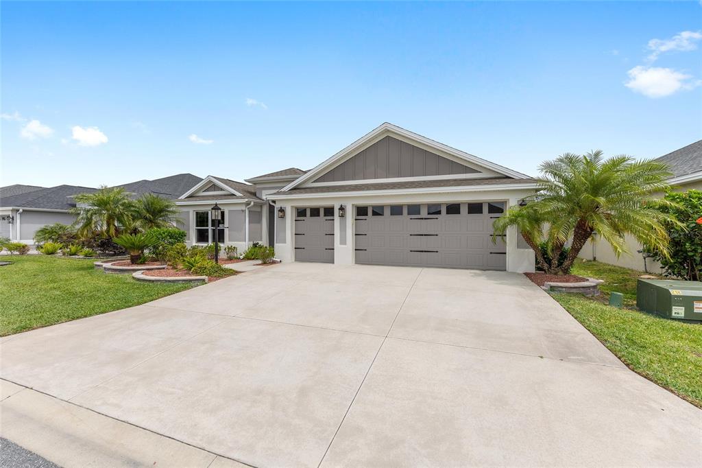 A single-story house with a three-car garage, gray siding, and a concrete driveway — 2140 BILLER CIRCLE, THE VILLAGES, FL
