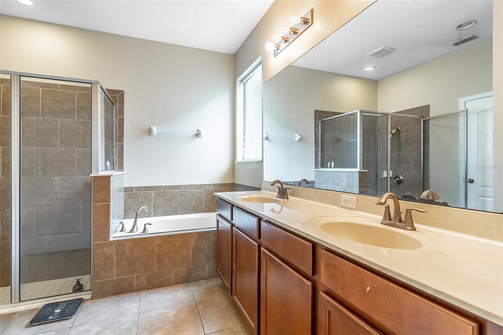 An open-concept living room and kitchen with tile flooring, a sectional sofa, and vaulted ceilings — 9907 ARMANDO CIRCLE, ORLANDO, FL