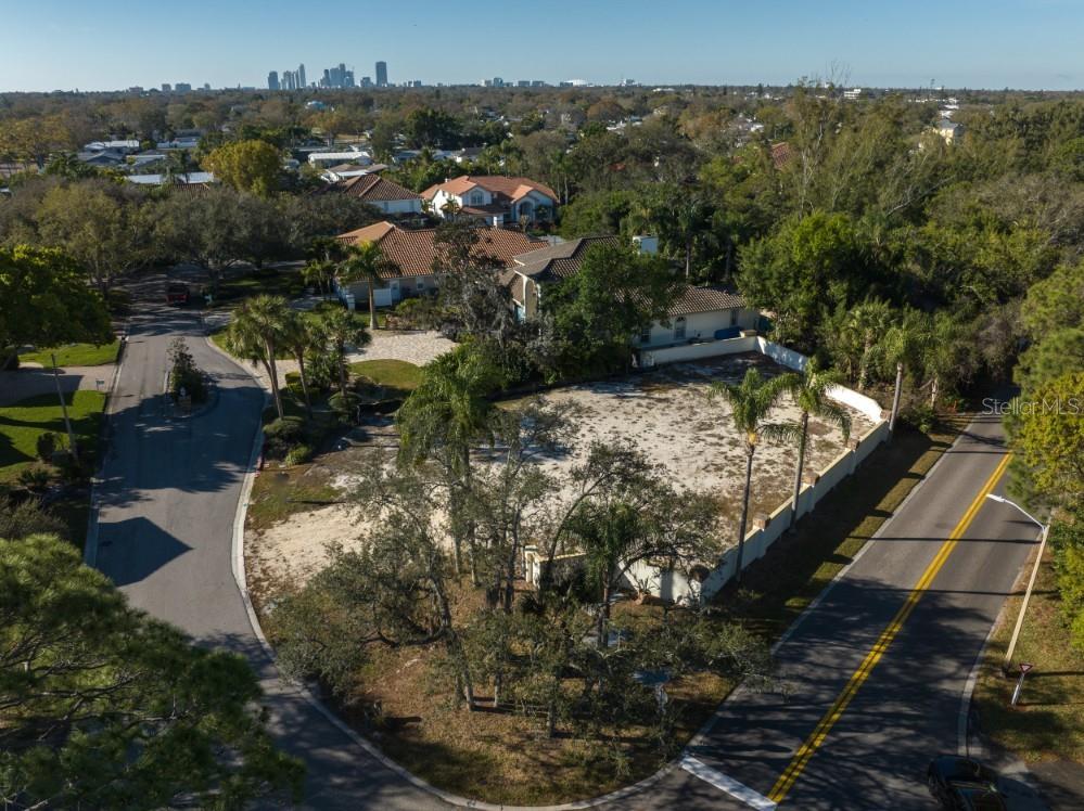 An aerial view shows a vacant, fenced residential lot situated between two paved roads — 4690 LAUREL OAK LANE NE, ST PETERSBURG, FL