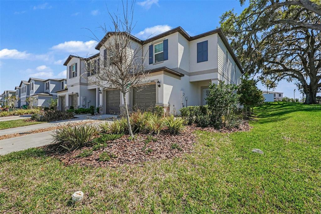 A two-story townhouse with a two-car garage and a landscaped front yard — 36456 WELL HILL WAY, ZEPHYRHILLS, FL