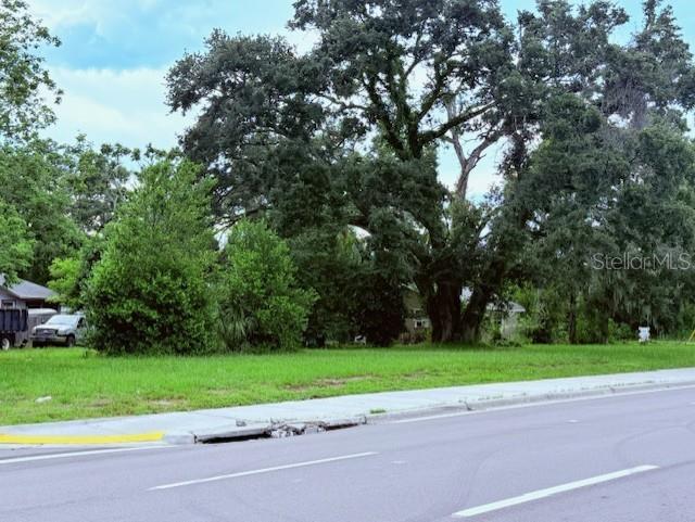 A grassy lot with large mature trees sits next to a paved road and sidewalk — 3415 21ST AVENUE S, ST PETERSBURG, FL