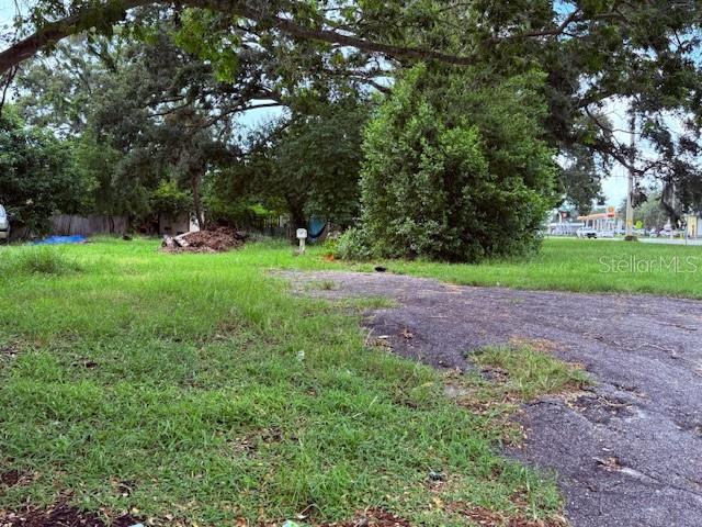 A grassy, tree-lined vacant lot features a patch of asphalt and a small utility box — 3415 21ST AVENUE S, ST PETERSBURG, FL