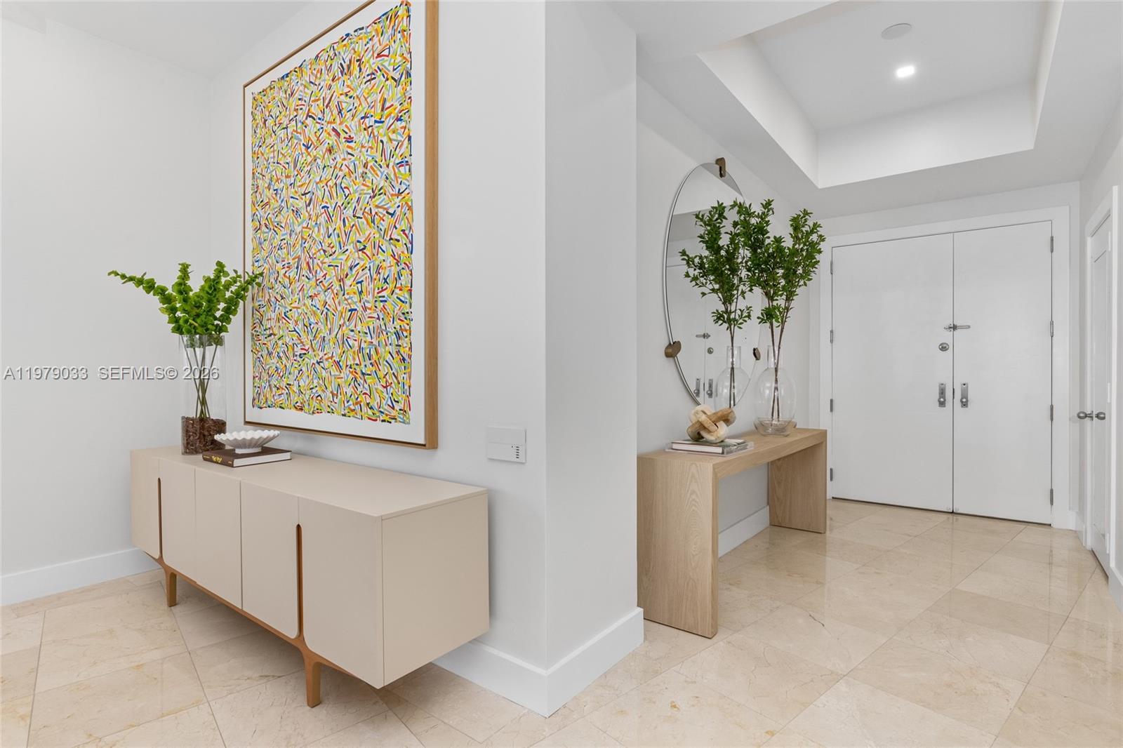 A bright entryway features a modern console table, abstract wall art, and a large mirror — 808 Brickell Key Dr # 3901, Miami FL 33131, MIAMI, FL