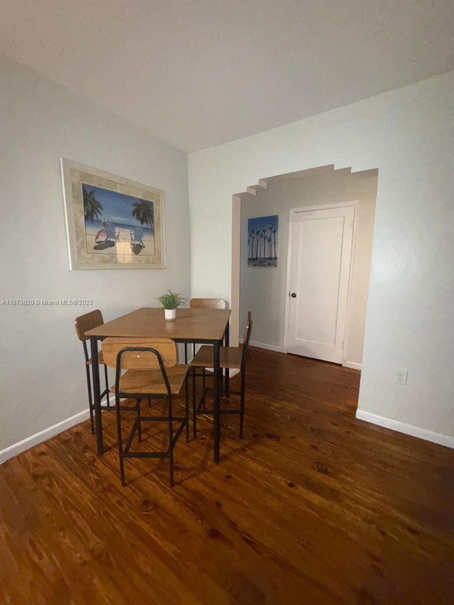 A dining area features a wooden table with four chairs and hardwood flooring — 1289 Marseille Dr # 46, Miami Beach FL 33141, MIAMI BEACH, FL