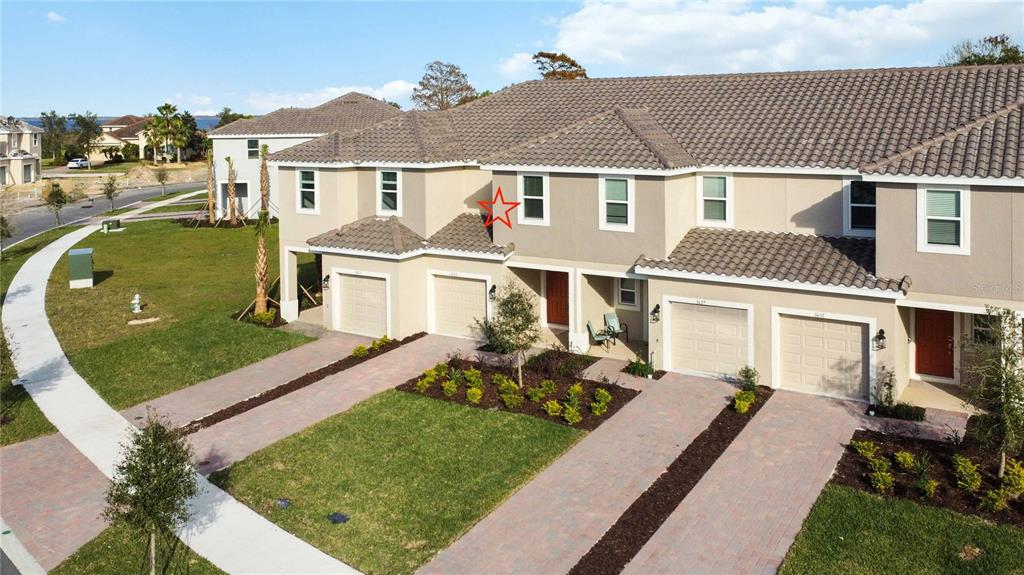 An exterior view of a multi-unit townhouse complex with beige stucco walls and tiled roofs — 3623 LANDING NET DRIVE, KISSIMMEE, FL