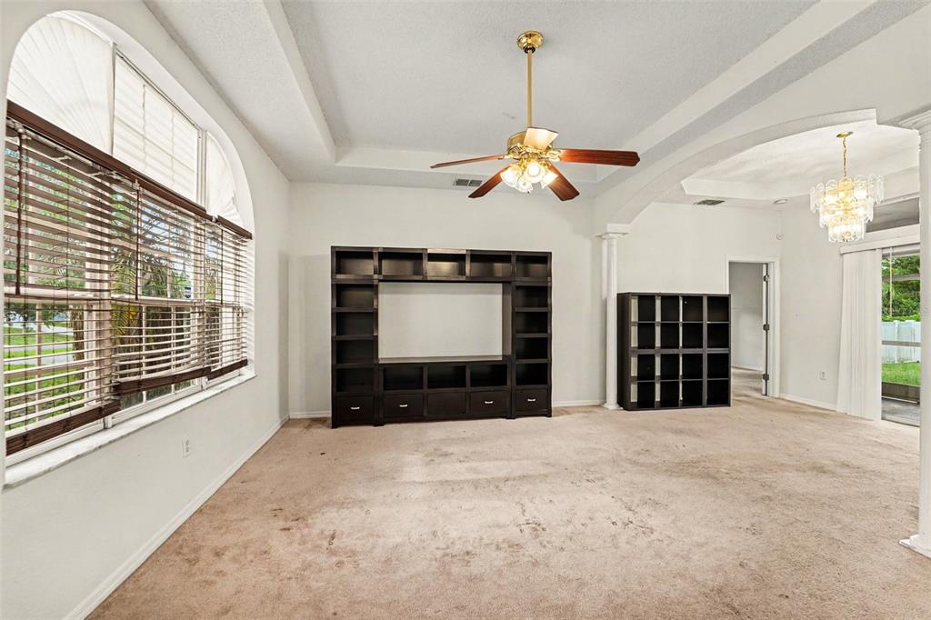 A dining area with a round table, four chairs, a bar cart, and large windows — 2405 AINSWORTH AVENUE, SPRING HILL, FL