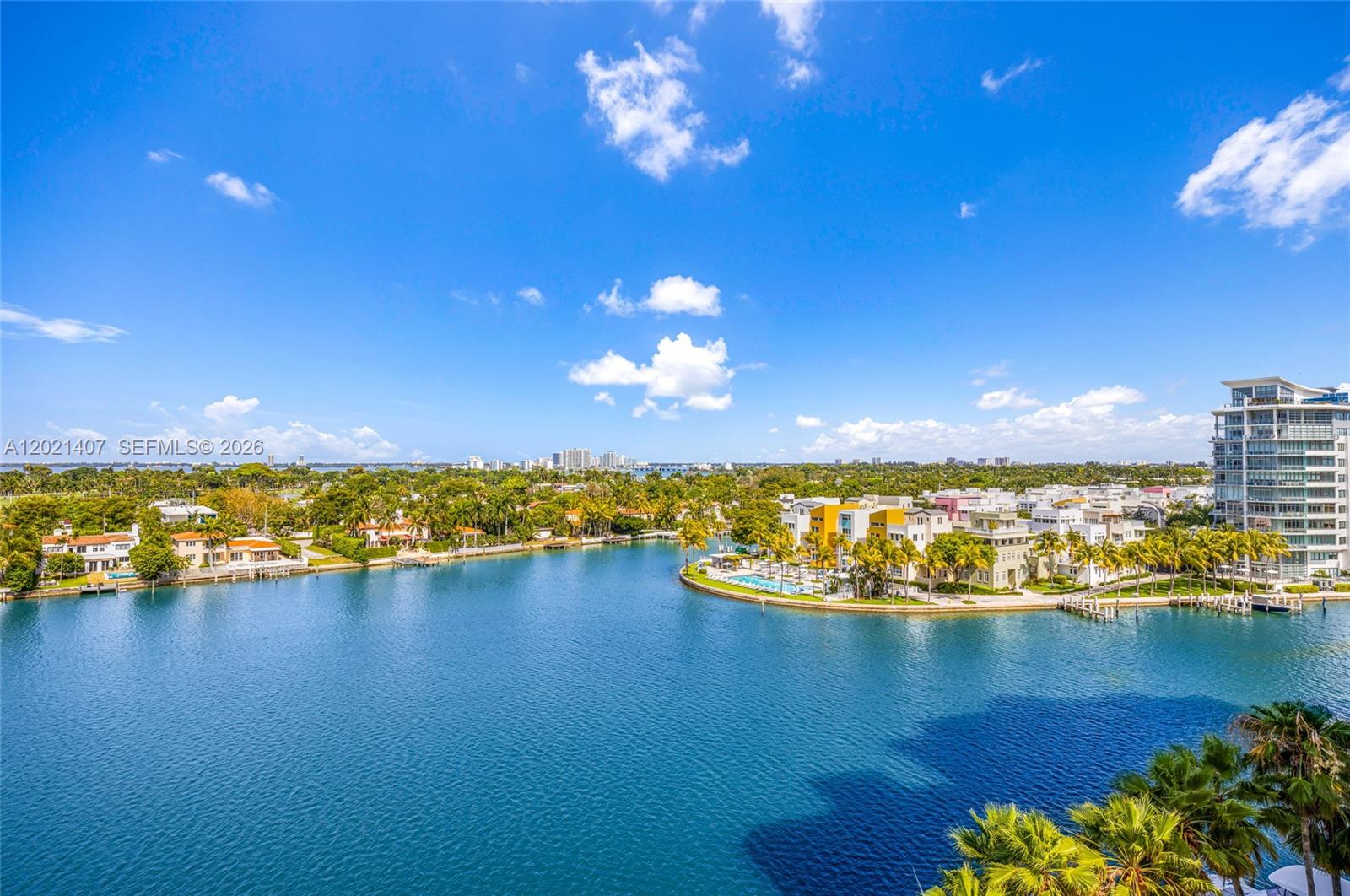 An aerial view shows a blue waterway surrounded by tropical landscaping and residential buildings — 5880 Collins Ave # 1007, Miami Beach FL 33140, MIAMI BEACH, FL