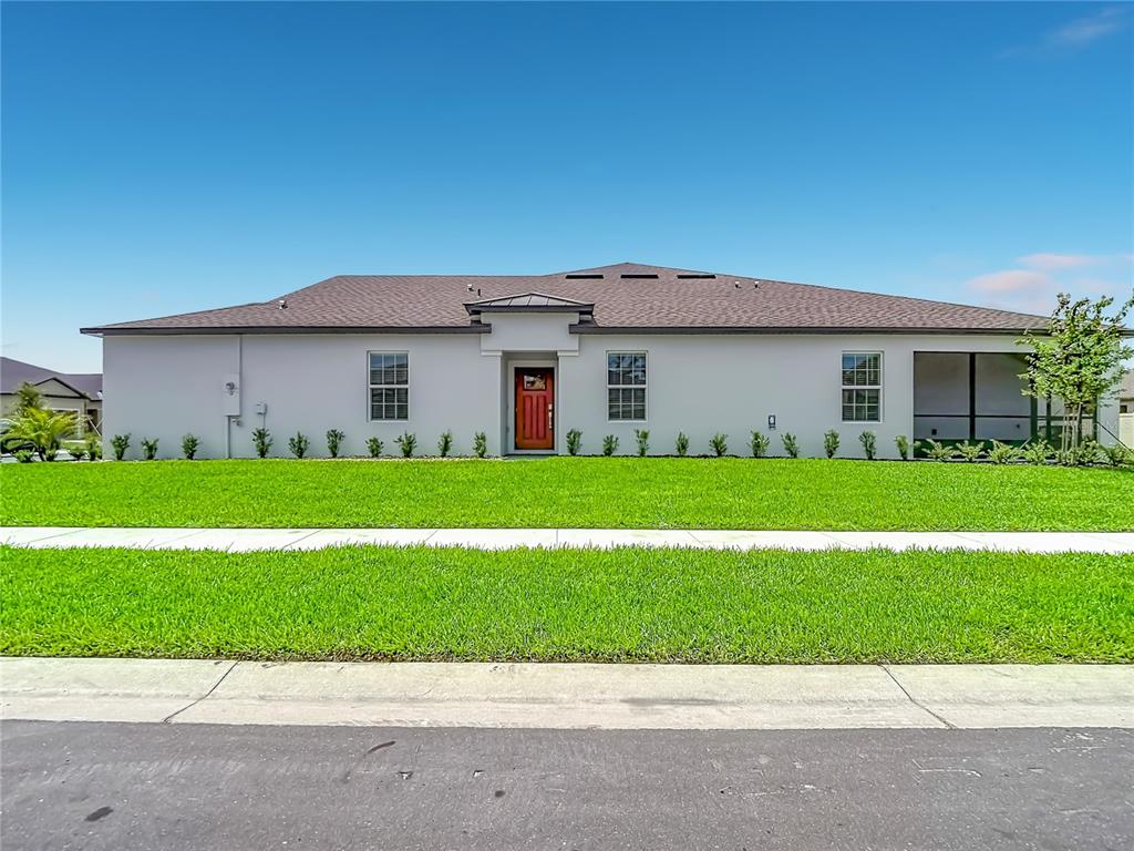 A single-story house with a light-colored exterior, a brown roof, and a red front door — 6799 HOMEBOUND WAY, NEW PORT RICHEY, FL