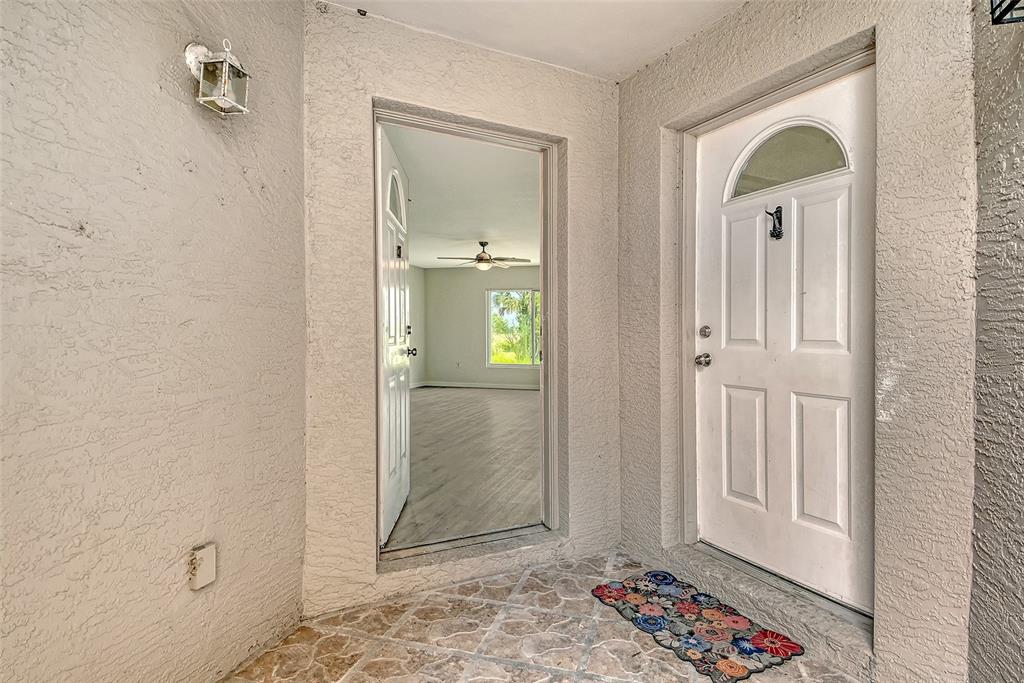 An exterior entryway with a white door, a tiled floor, and a view into an interior — 383 BOBBY JONES ROAD UNIT 383, SARASOTA, FL