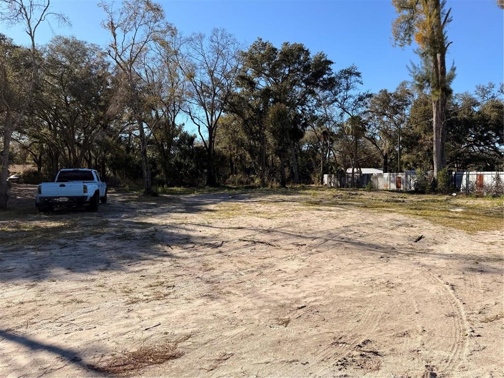 A white pickup truck is parked on a sandy, partially wooded vacant lot — 6806 NEW YORK DRIVE Lot C, TAMPA, FL