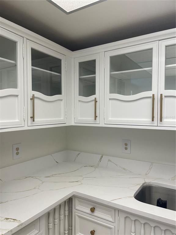 A kitchen corner features white cabinets with glass inserts, gold hardware, and marble-patterned countertops — 5200 BRITTANY DRIVE S UNIT 1804, ST PETERSBURG, FL