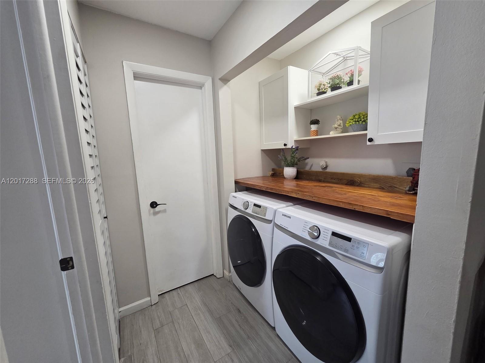 A laundry room features white Samsung appliances, a wooden countertop, and white wall cabinets — 19 Chestnut Cir, Cooper City FL 33026, COOPER CITY, FL