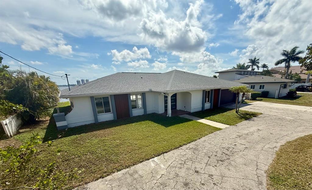 A single-story house with a gray roof, white siding, and a concrete driveway — 111 E NORTH SHORE AVENUE, NORTH FORT MYERS, FL