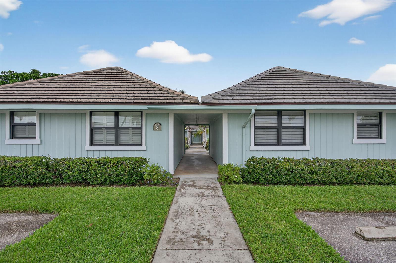 A light blue single-story building with a central walkway and a tiled roof — 1127 E Seminole Avenue # 8a, Jupiter FL 33477, JUPITER, FL