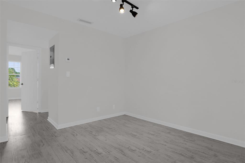 An empty room with light gray walls, wood-look flooring, and a ceiling track light — 754 E MICHIGAN STREET UNIT 174, ORLANDO, FL
