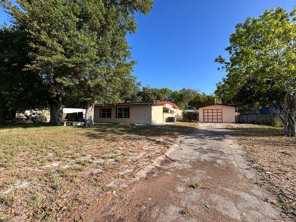 A single-story house with a detached garage sits on a large, grassy lot — 340 SANTA BARBARA STREET, NORTH FORT MYERS, FL