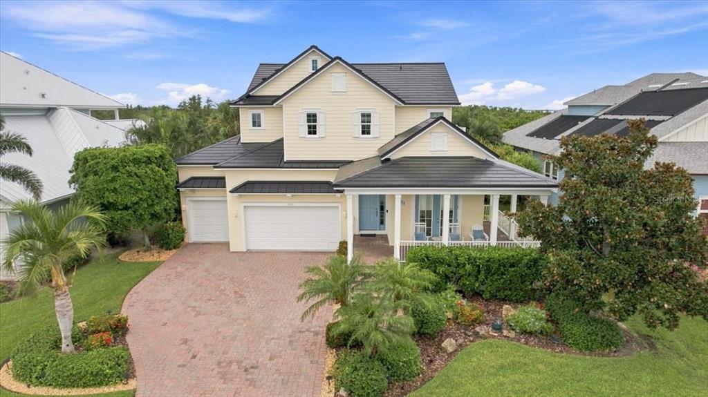 A two-story house with a cream exterior, dark roof, and a brick driveway — 8124 37TH AVENUE CIRCLE W, BRADENTON, FL