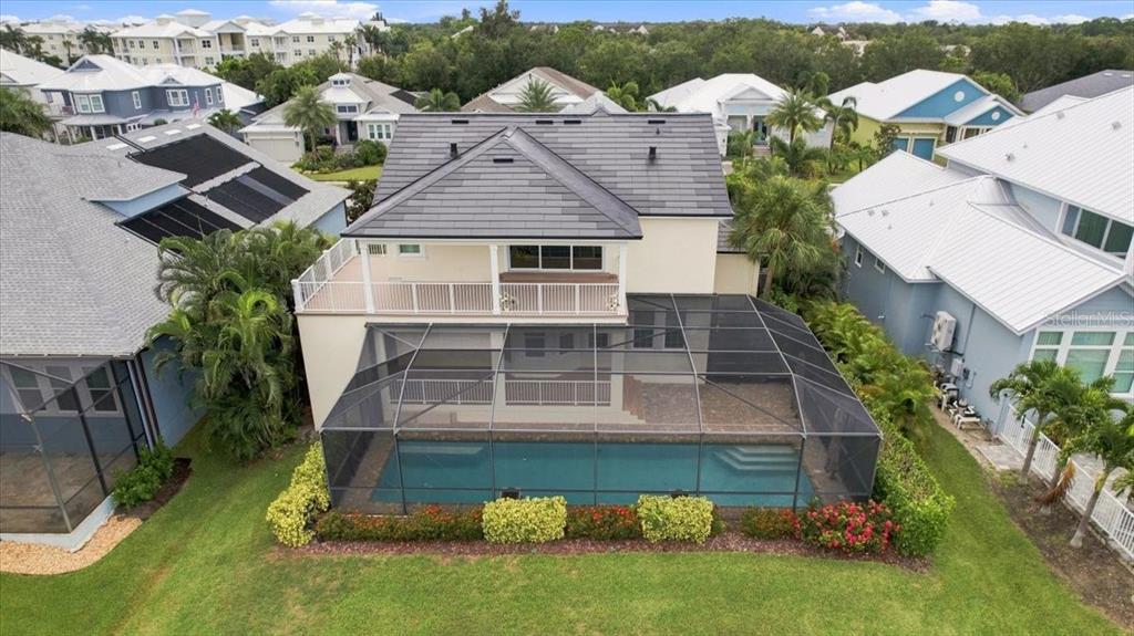 An aerial view of a two-story house featuring a screened-in pool and a second-floor balcony — 8124 37TH AVENUE CIRCLE W, BRADENTON, FL