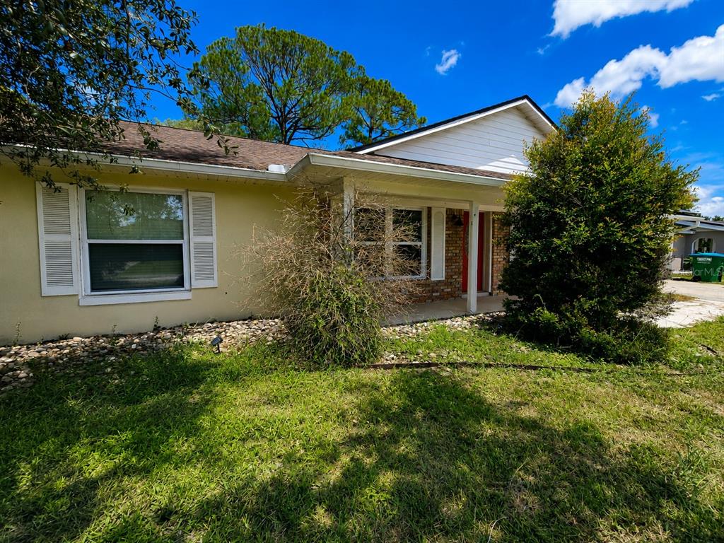 A single-story house with a yellow exterior, white shutters, and a covered front porch — 1432 LANDOVER AVENUE, DELTONA, FL
