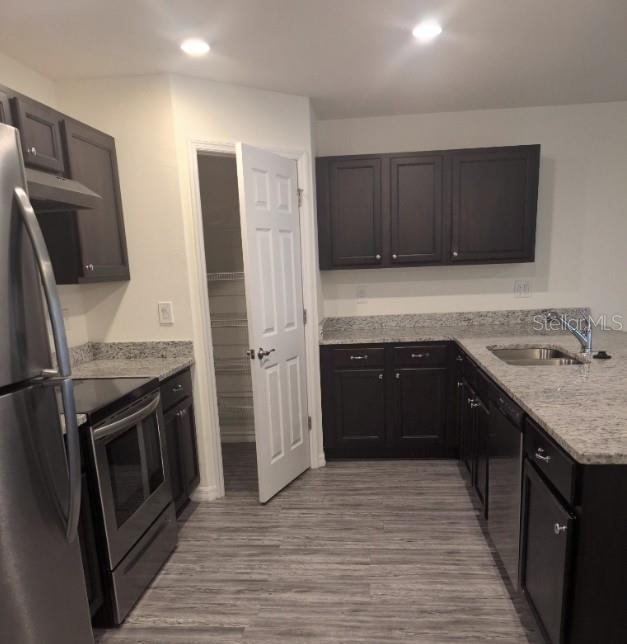 A kitchen features dark wood cabinets, granite countertops, stainless steel appliances, and a pantry closet — 26245 NORTHERN CROSS ROAD, PUNTA GORDA, FL