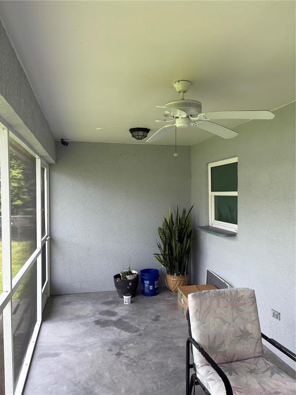A covered patio features a ceiling fan, concrete flooring, a screen wall, and a window — 2789 RHUMBA TERRACE, NORTH PORT, FL
