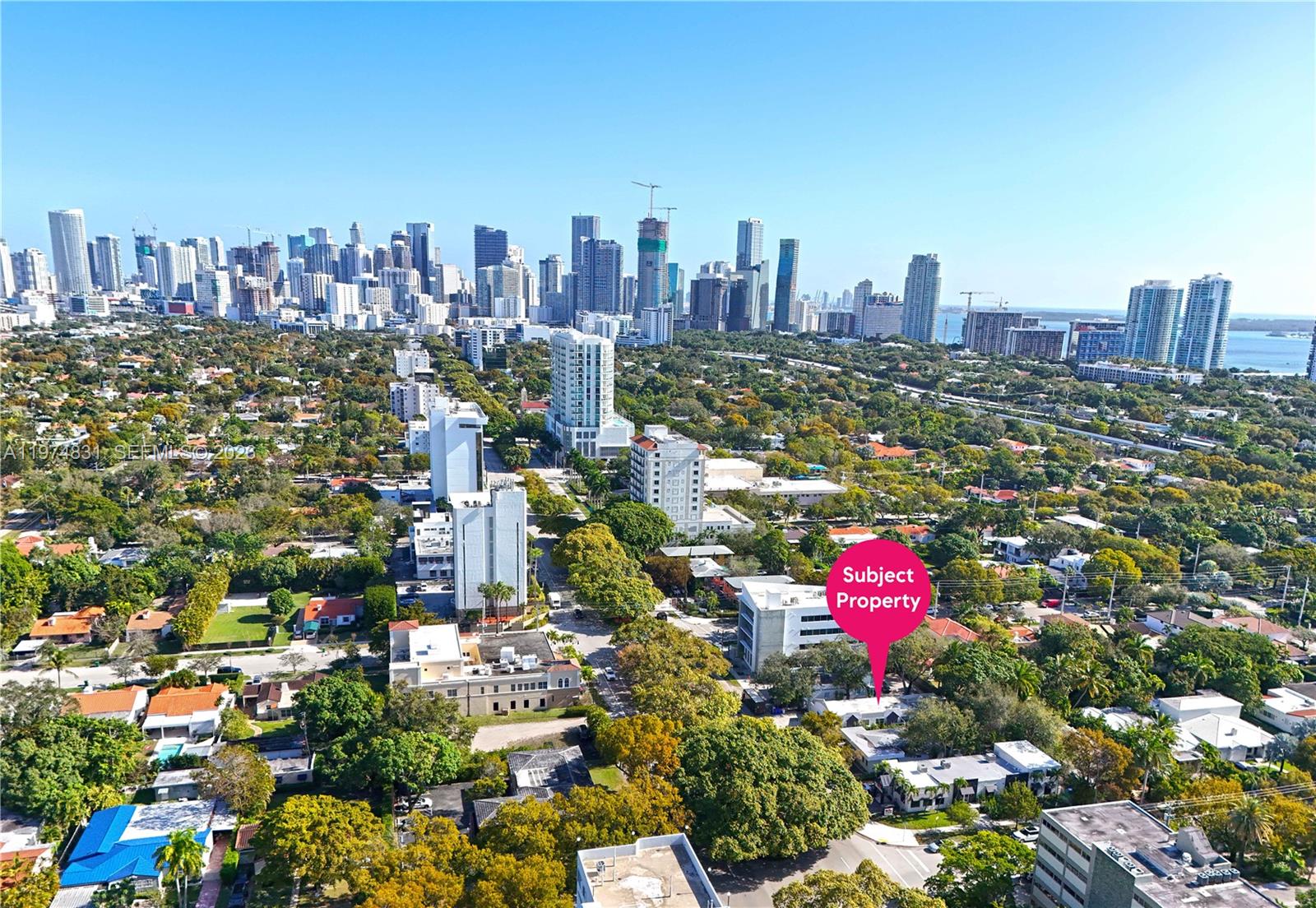 An aerial view shows a low-rise building marked as the subject property amidst urban greenery — 2825 SW 3rd Ave, Miami FL 33129, MIAMI, FL