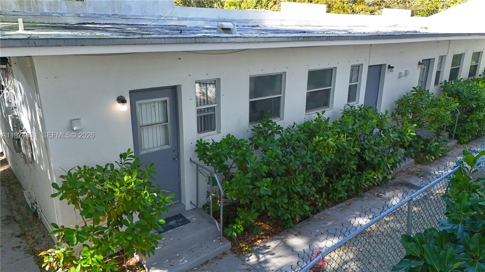 An exterior view of a white, single-story building with gray doors and windows — 2825 SW 3rd Ave, Miami FL 33129, MIAMI, FL