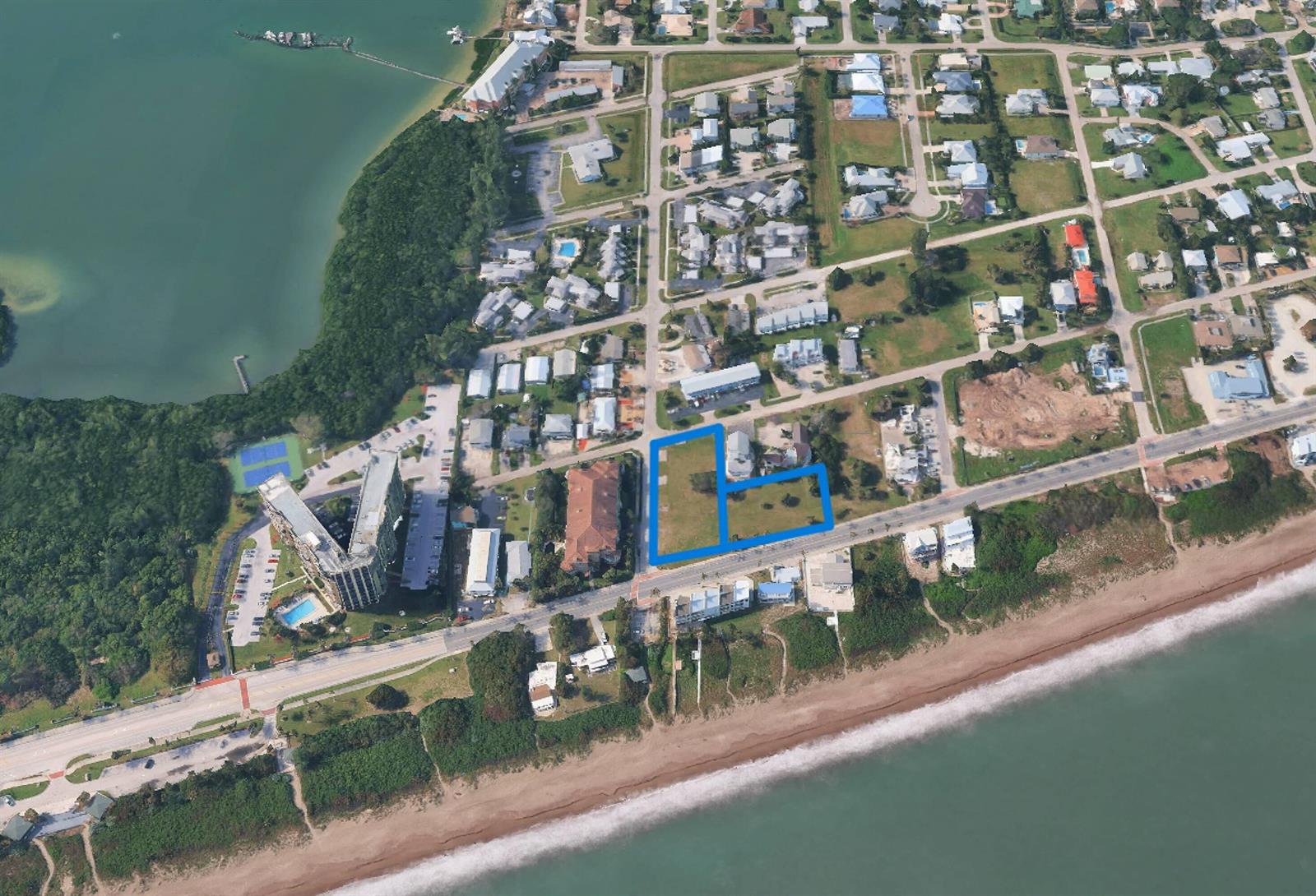 An aerial view shows a vacant, L-shaped parcel of land near a beach and road — 609 & 615 S Ocean Drive, Fort Pierce FL 34949, FORT PIERCE, FL