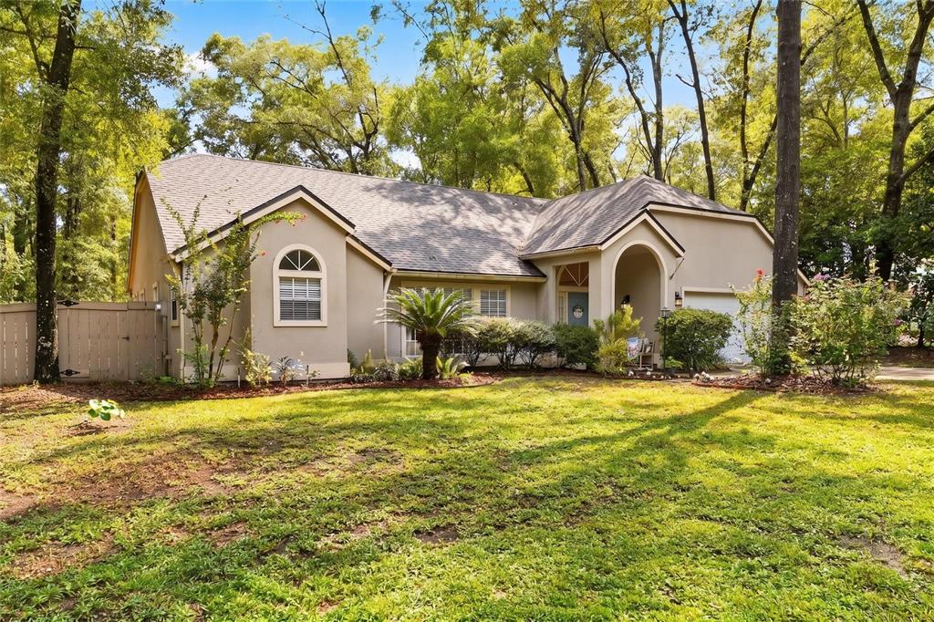 An aerial view of a single-story house with a two-car garage and a concrete driveway — 10427 SW 55TH PLACE, GAINESVILLE, FL