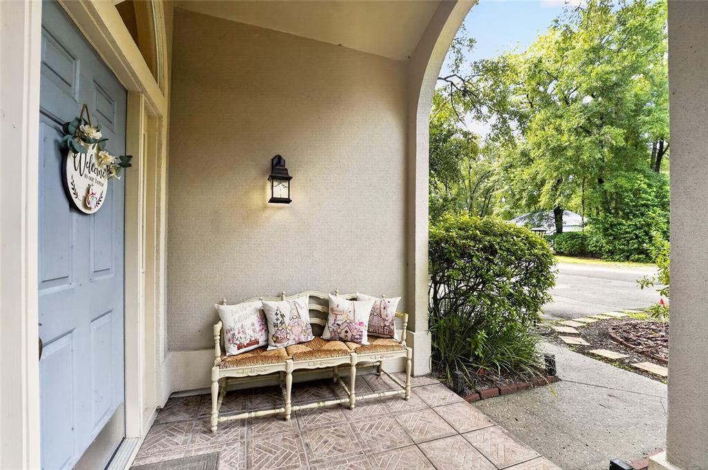 An entryway with tile flooring leads to a living area with wood floors and vaulted ceilings — 10427 SW 55TH PLACE, GAINESVILLE, FL