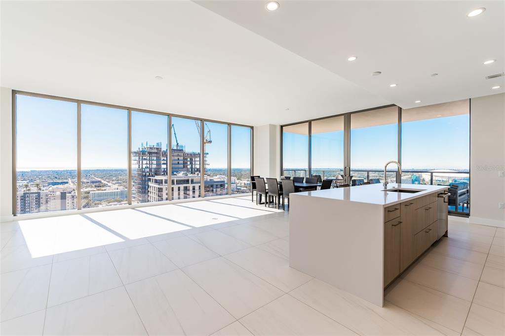 A modern lobby features a curved sofa, a central coffee table, and floor-to-ceiling windows — 275 1ST AVE SOUTH UNIT 2606, ST PETERSBURG, FL