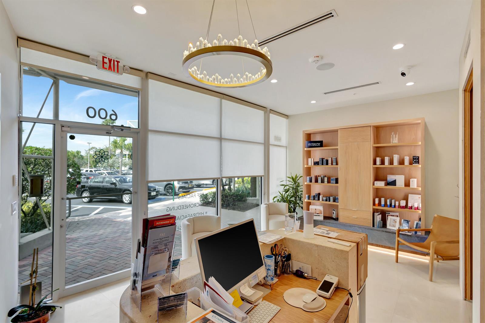 A bright reception area features a stone desk, a crystal chandelier, and built-in wooden shelving — 2151 Fl A1aalt, Jupiter FL 33477, JUPITER, FL