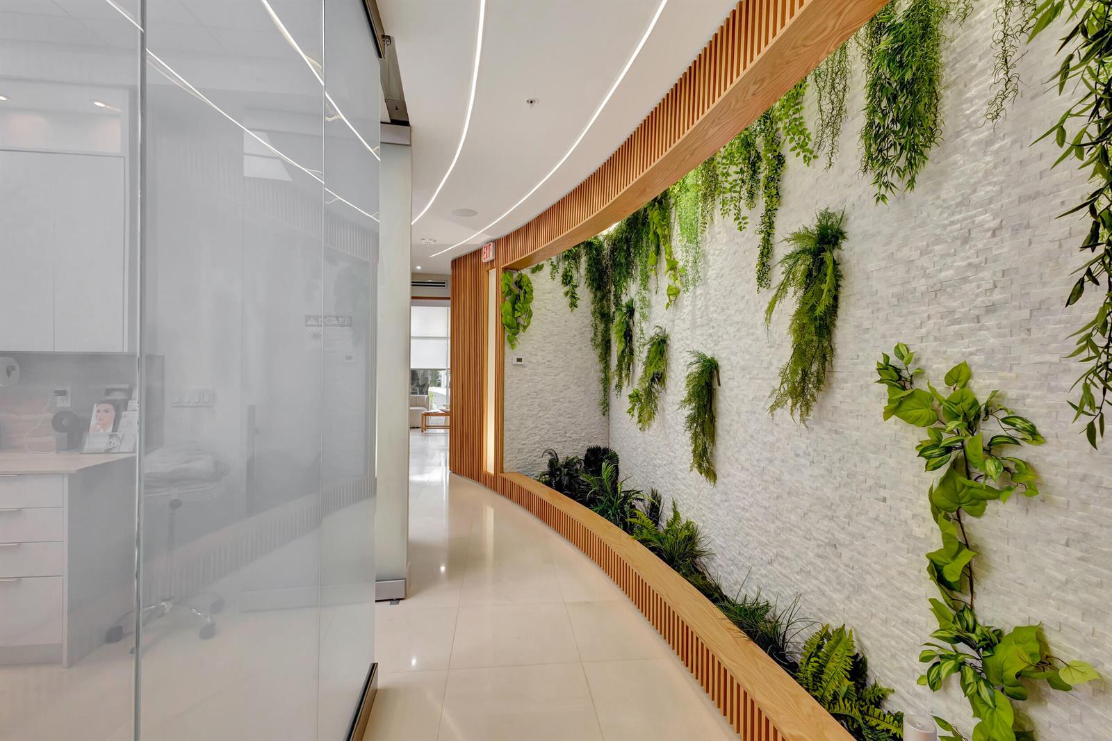 A curved hallway features a white stone wall with hanging plants and wood slat accents — 2151 Fl A1aalt, Jupiter FL 33477, JUPITER, FL
