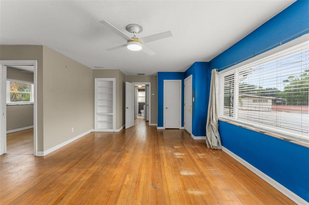 A living room with blue walls, hardwood floors, a ceiling fan, and an adjacent sunroom — 1714 N BUMBY AVENUE, ORLANDO, FL