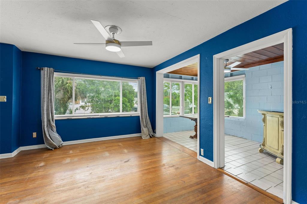 A living room with hardwood floors, a ceiling fan, and a blue accent wall — 1714 N BUMBY AVENUE, ORLANDO, FL