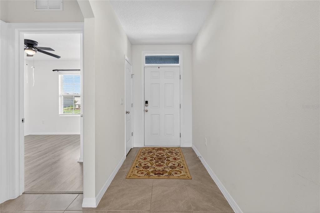 A tiled entryway leads to a white front door with a transom window — 2658 GRANDBURY GROVE ROAD, LAKELAND, FL