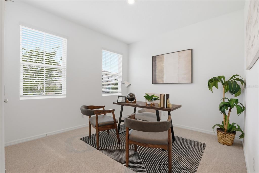 A home office features a wooden desk, two chairs, a rug, and a potted plant — 725 FARFIELDS STREET, DELAND, FL
