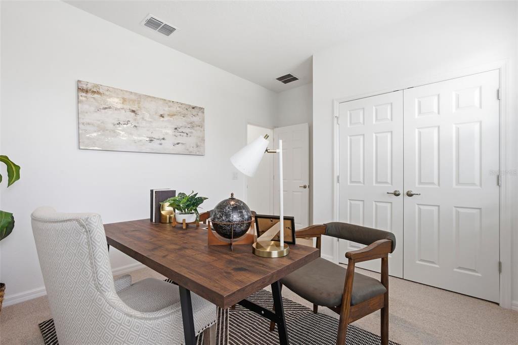 A home office features a wooden desk, two chairs, a globe, and white double doors — 725 FARFIELDS STREET, DELAND, FL