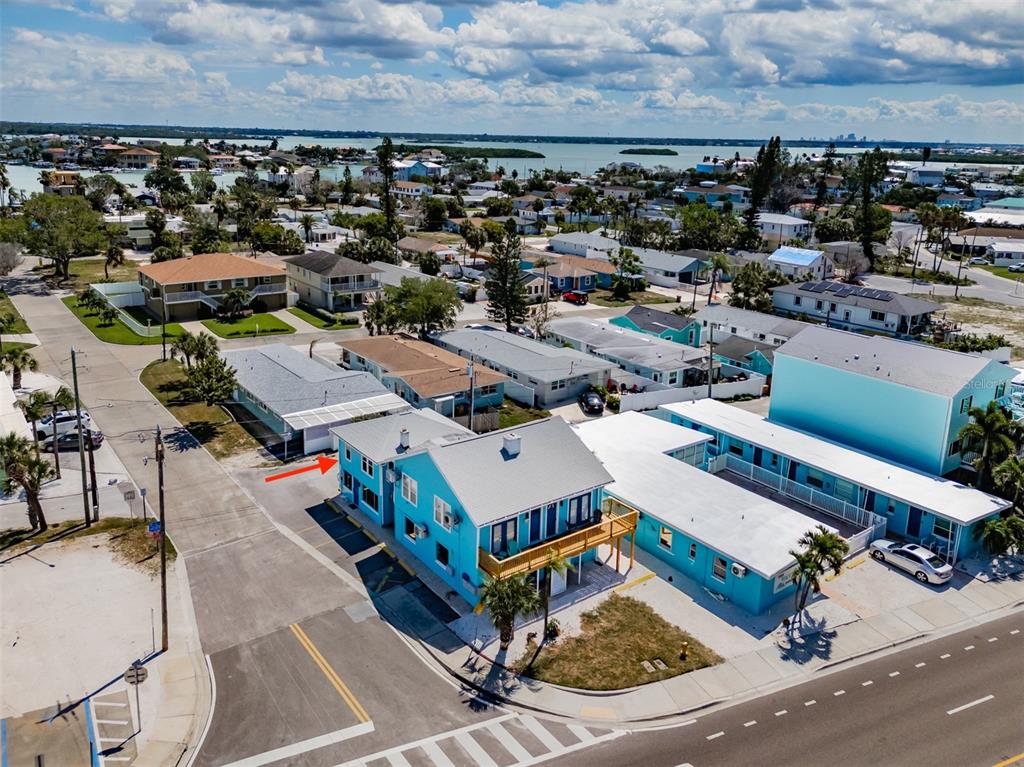 An aerial view shows a bright blue multi-unit building located on a corner lot — 13343 GULF BOULEVARD UNIT 14, MADEIRA BEACH, FL