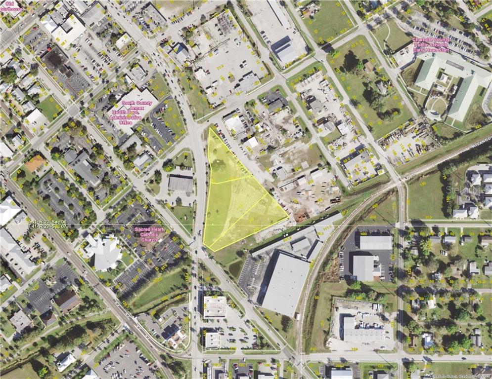 An aerial map view shows a vacant, yellow-highlighted triangular lot surrounded by city streets and buildings — 500 TAMIAMI TRAIL, PUNTA GORDA, FL