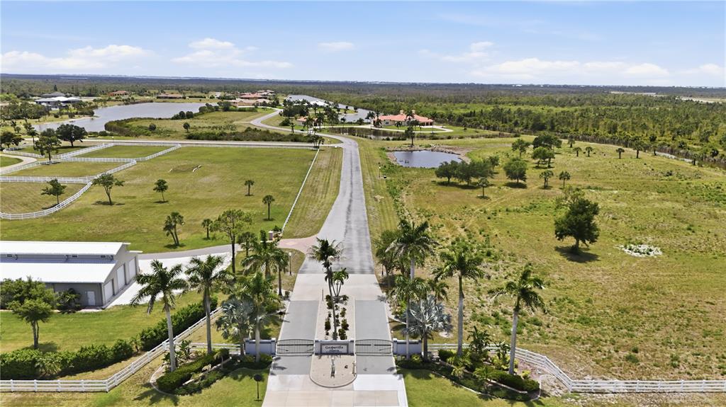 An aerial view shows a gated entrance leading to a rural property with pastures and ponds — 11610 BRIDLE PATH LANE, PLACIDA, FL