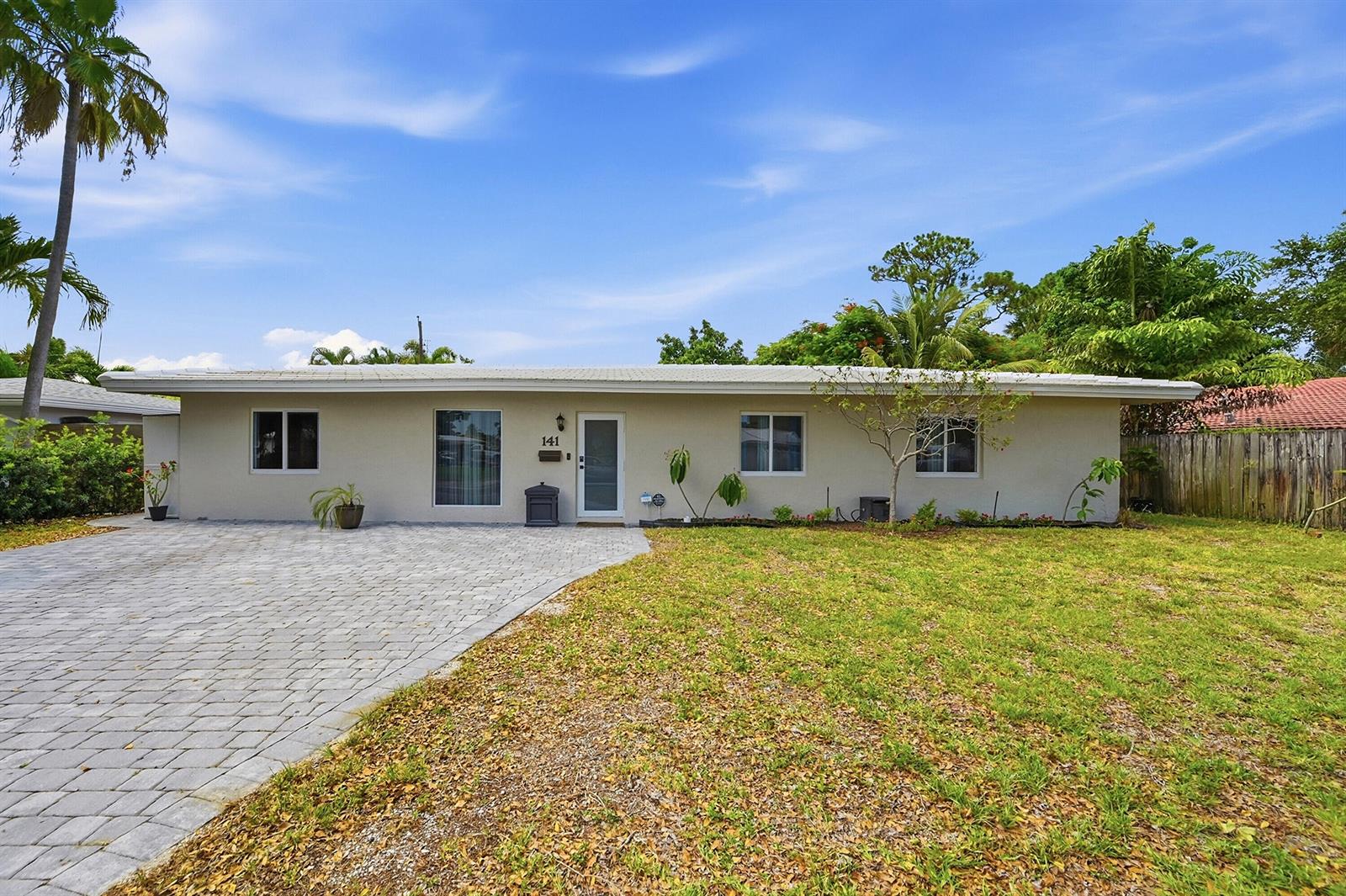 A kitchen island with a built-in microwave and stove sits in an open-concept living space — 141 SE 8th Street, Pompano Beach FL 33060, POMPANO BEACH, FL